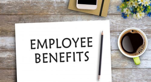 EMPLOYEE BENEFITS text on paper on wooden table with coffee cup and smartphone. Business concept of positive thinking and motivation. Flat lay with blank copy space top view.
